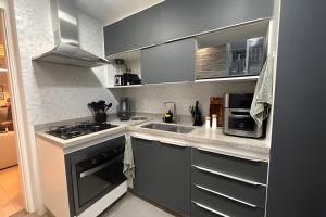 a kitchen with a sink and a stove top oven at Apto Luxuoso, 50 Mts da Praia em Copacabana para 6 in Rio de Janeiro