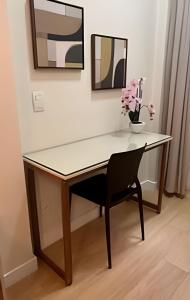 a desk with a chair and a vase of flowers at Apto Luxuoso, 50 Mts da Praia em Copacabana para 6 in Rio de Janeiro