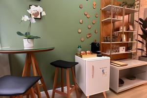 a kitchen with a small refrigerator and a table and stools at Apto Luxuoso, 50 Mts da Praia em Copacabana para 6 in Rio de Janeiro