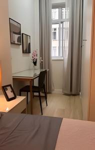 a bedroom with a desk and a table with a chair at Apto Luxuoso, 50 Mts da Praia em Copacabana para 6 in Rio de Janeiro