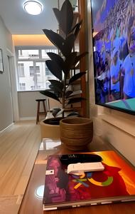 a living room with a tv and a remote control at Apto Luxuoso, 50 Mts da Praia em Copacabana para 6 in Rio de Janeiro