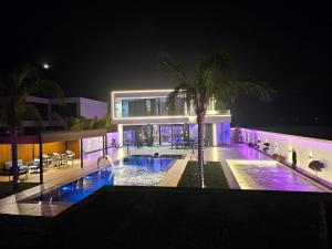 a building with a swimming pool at night at Alfa Villa in Rrushkull