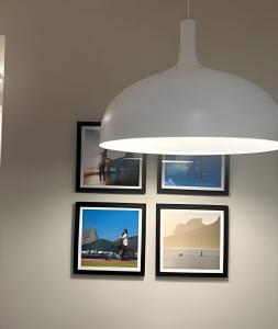 a group of pictures on a wall with a light fixture at Apto Luxuoso, 50 Mts da Praia em Copacabana para 6 in Rio de Janeiro