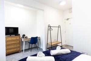 奧爾德姆的住宿－Suite 4 - Trendy Spot in Oldham City Centre，一间卧室配有一张床、一张桌子和一把椅子