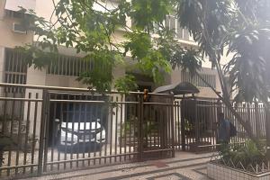 a fence with a table and an umbrella in front of a building at Apto Luxuoso, 50 Mts da Praia em Copacabana para 6 in Rio de Janeiro