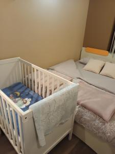 a nursery with two twin beds and a crib at Guest house - studio apartman Marina in Karlovac