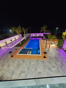 una piscina por la noche con luces moradas en Alfa Villa, en Rrushkull