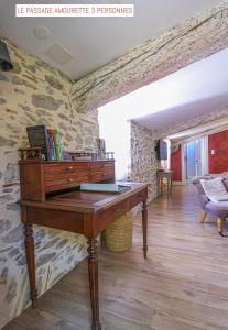 un piano de madera en una habitación con una pared de piedra en Le Passage, en Carcassonne