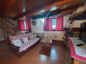 un salon avec un canapé et une table dans l'établissement Maison Sarteur Alloggio ad uso turistico -VDA-LA THUILE- 0065, à La Thuile