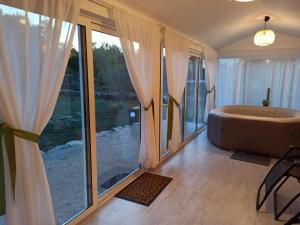 a bathroom with a tub and a large window at Holiday House Vela Vrta in Sveti Ivan Dobrinjski