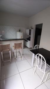 a kitchen with a table and two chairs and a counter at Stúdio Cozy in Palmas