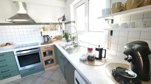 cocina con fregadero y fogones horno superior en Plant Apartment en Eutingen
