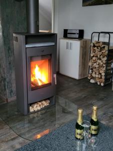 a fireplace with two bottles of wine and two wine glasses at Ferienwohnung 2 - a72142 in Wangerland