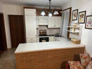 une cuisine avec des placards blancs et un comptoir en briques dans l'établissement Ares House, à Torri di Quartesolo