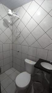 La salle de bains blanche est pourvue de toilettes et d'un lavabo. dans l'établissement Stúdio Cozy, à Palmas
