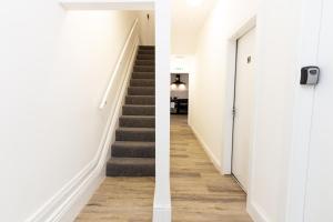 a hallway with stairs and a hallway with white walls at Suite 4 - Trendy Spot in Oldham City Centre in Oldham