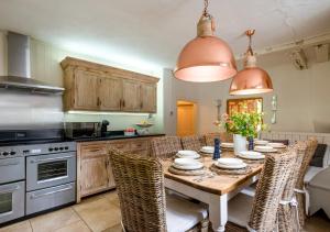 uma cozinha com uma mesa com cadeiras e um fogão em Church Farm em Halesworth
