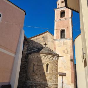 a church with a clock tower in a street at Casa Vacanze AL TEATRO in Diano Castello