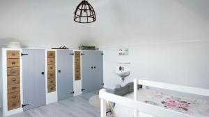 a bedroom with white cabinets and a bed and a sink at Romantisch Vakantiehuis de Hooiberg in Berkenwoude