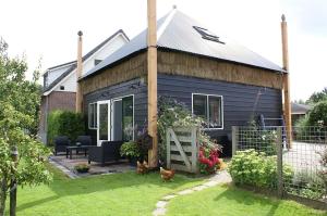a blue house with two cats in front of it at Romantisch Vakantiehuis de Hooiberg in Berkenwoude +5 photos