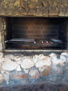 a stone brick oven with a metal grate at Pousada Espaço Cosmos in Águas da Prata