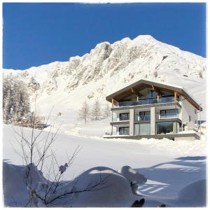 um edifício na neve em frente a uma montanha em Pezza 21 em Samnaun