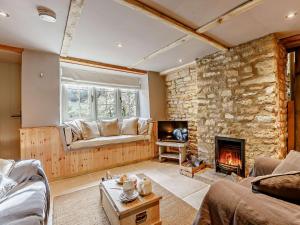 a living room with a stone wall and a fireplace at 1 Bed in Longborough 52674 in Longborough