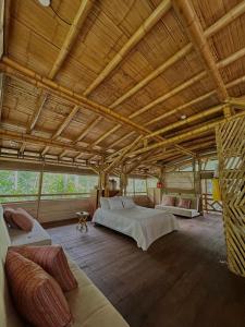 Habitación grande con 2 camas y sofá en Oasis Santuario de Naturaleza en Ibagué