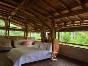 a bedroom with a bed in a room with windows at Oasis Santuario de Naturaleza in Ibagué