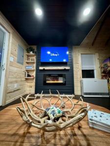 a room with a large antlers on a table with a tv at Brook Haven Retreat - Minutes to Mt Snow / Stratton, Pet Friendly! in Wardsboro