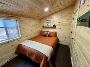a bedroom in a log cabin with a bed in it at Brook Haven Retreat - Minutes to Mt Snow / Stratton, Pet Friendly! in Wardsboro