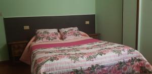 a bed with two pillows and a pink blanket at Hostal Fisterra in Lugo