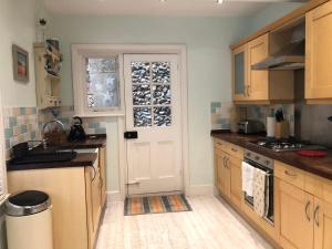 a kitchen with wooden cabinets and a white door at Seaview Cottage in Broadstairs