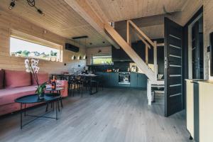 Il dispose d'une cuisine ouverte et d'un salon avec un canapé et des tables. dans l'établissement Ostoja pod Osówką Dom Cisza, à Sierpnica