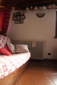 une chambre avec un lit et un radiateur dans l'établissement Maison Sarteur Alloggio ad uso turistico -VDA-LA THUILE- 0065, à La Thuile