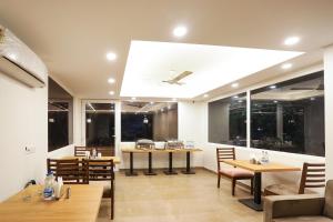 a dining room with tables and chairs and windows at Townhouse MA-32 in Gurgaon