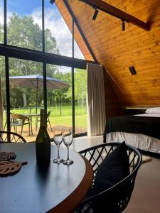einen Tisch mit zwei Weingläsern und einer Flasche in der Unterkunft Chalé Caminhos do Salto Ventoso in Farroupilha