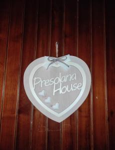 a heart shaped sign hanging on a wooden wall at Presolana House in Castione della Presolana