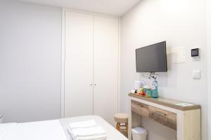um quarto com uma cama e uma televisão na parede em Bella Gaia - Alojamento Local em Vila Nova de Gaia