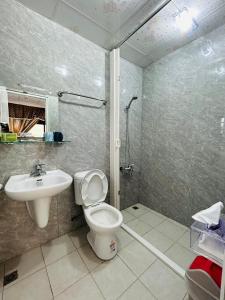 uma casa de banho com um WC, um lavatório e um chuveiro em Hello em Fang-liao