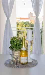 a bottle of wine and glasses on a table at LUX Apartment in Split