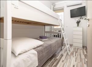 a bedroom with a bunk bed with a tv and a ladder at LUX Apartment in Split