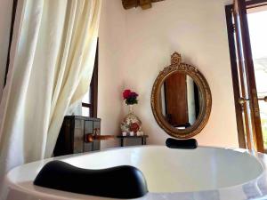 eine Badewanne in einem Zimmer mit Spiegel in der Unterkunft Rancho Fiori di Mari - Lago Corumbá IV in Alexânia