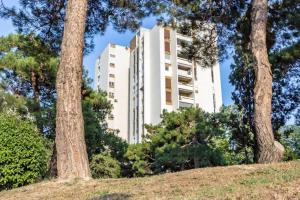 a tall white building in the middle of trees at LUX Apartment in Split