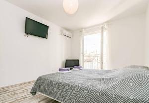 a white bedroom with a bed and a flat screen tv at LUX Apartment in Split