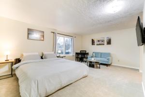 een slaapkamer met een wit bed en een blauwe stoel bij Hillsboro Home with Fire Pit about 15 Mi to Portland! in Hillsboro
