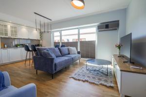 een woonkamer met een blauwe bank en een tafel bij Tähe Delux Apartment in Tartu