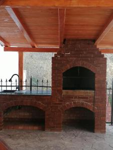 an outdoor brick oven with a wooden roof at La Colette in Dubova
