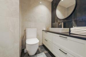 een badkamer met een wit toilet en een spiegel bij Tähe Delux Apartment in Tartu