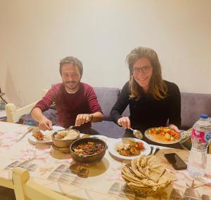 un homme et une femme assis à une table avec des assiettes de nourriture dans l'établissement Nefertarie Guest House, à Louxor